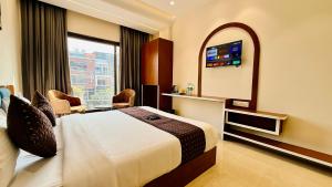 a hotel room with a bed and a large window at Hotel Mantri Ji in Ujjain +45 photos