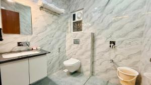 a bathroom with a white toilet and a sink at Hotel Mantri Ji in Ujjain