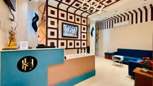 a waiting room with a blue couch and a counter at Hotel Mantri Ji in Ujjain
