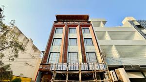 a tall building with a balcony in front of it at Hotel Mantri Ji in Ujjain