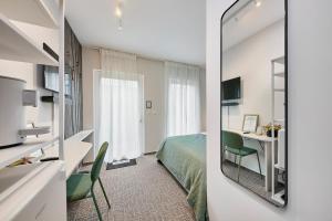 a hotel room with a bed and a mirror at Neubau - Citynah & Modern in Hamburg Niendorf in Hamburg +1 photo