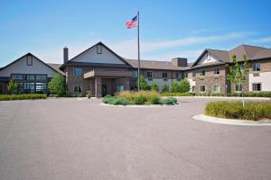 a building with an american flag in front of it at GrandStay Inn & Suites of Luverne in Luverne