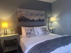 a bedroom with a bed with two lamps and a painting at MisyEdz Homes Clark Dau in Mabalacat