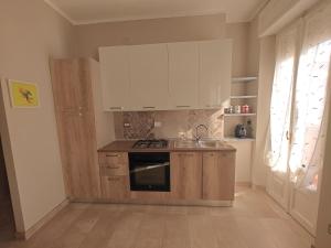 Una cocina con gabinetes blancos y un fregadero. en Mavin Apartments Cuneo, en Cuneo