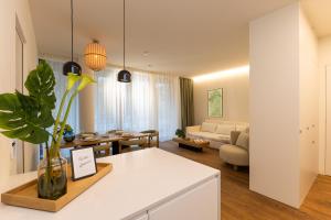 a kitchen and living room with a couch and a table at BLOOM-Living in Linz