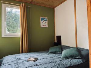 a bedroom with a large bed with a window at Chalet 3 étoiles - ccbecih in Chézery-Forens