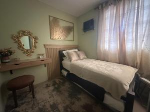 a small bedroom with a bed and a mirror at MisyEdz Homes Clark Dau in Mabalacat
