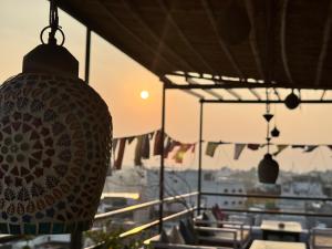 a lamp hanging from a building with tables and chairs at Pink Floyd in Pushkar