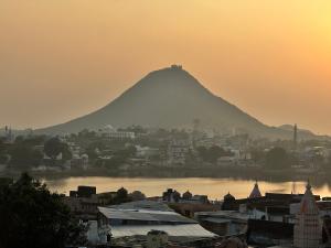 a view of a mountain with a city and a body of water at Pink Floyd in Pushkar