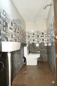 a bathroom with a sink and a toilet and a shower at Nilaya in Varanasi