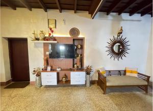 a living room with a couch and a tv at The Boho Cochin in Cochin