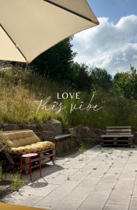 una panchina e un ombrello con la scritta love thats ville di eifelhausaufzeit Wellness Yoga Sauna-exklusiv-nachhaltig-ökologisch a Immerath
