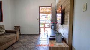 Una sala de estar con un sofá y una puerta abierta. en Sitio em Aracariguama com Piscina e Churrasqueira, en Araçariguama