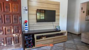 Una sala de estar con un televisor de pantalla plana en un centro de entretenimiento. en Sitio em Aracariguama com Piscina e Churrasqueira, en Araçariguama