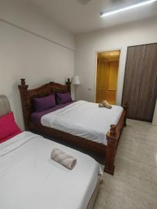 two beds in a room with purple and white at By The Sea Beach Front and Seaview Apartment 2 in Batu Ferringhi +21 photos