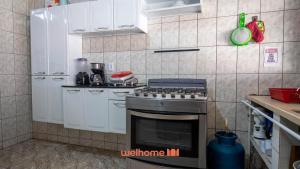 una cucina con fornelli e mobili bianchi di Sitio em Aracariguama com Piscina e Churrasqueira a Araçariguama