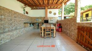 una cucina con tavolo e muro di mattoni di Sitio em Aracariguama com Piscina e Churrasqueira a Araçariguama