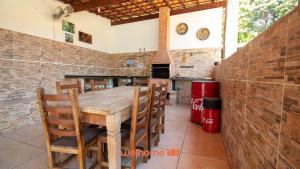 una sala da pranzo con tavolo e sedie in legno di Sitio em Aracariguama com Piscina e Churrasqueira a Araçariguama Altre 8 foto