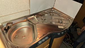 a kitchen with a sink and a stove at Wohnwagen mit feststehendem Vorzelt in Fehmarn +23 photos