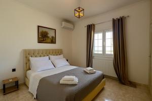 a bedroom with a bed with two towels on it at Olivia Estate South Corfu in Bastátika +43 photos
