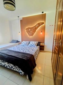 a bedroom with a bed with a painting on the wall at Surf Harbour Homestay in Los Abrigos +13 photos