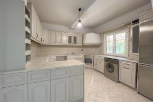 a large kitchen with white cabinets and a dishwasher at Olivia Estate South Corfu in Bastátika