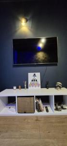 a white shelf with a flat screen tv on a wall at Apartament Na Rynku in Bytom