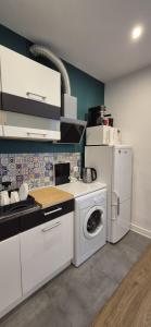 a kitchen with a washing machine and a refrigerator at Apartament Na Rynku in Bytom