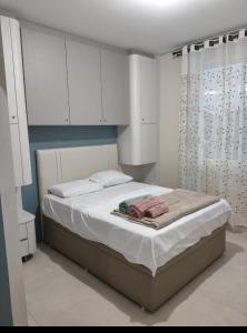 a bedroom with a bed with white cabinets at Apto ALTO PADRÃO com Churrasqueira, Cama Ortopedica e ar Condicionado 300m da praia acomoda 06 PESSOAS in Piçarras
