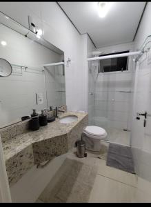 a bathroom with a toilet and a sink and a shower at Apto ALTO PADRÃO com Churrasqueira, Cama Ortopedica e ar Condicionado 300m da praia acomoda 06 PESSOAS in Piçarras