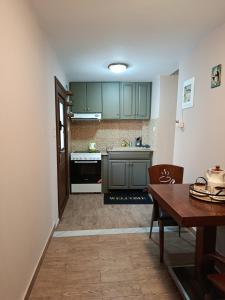 Kalymnos Center Sea Port في كاليمنوس: مطبخ مع دواليب خضراء وطاولة خشبية