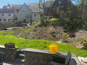 a yellow watering can sitting on a table in a yard at Ferienhaus Moritz in Ippesheim