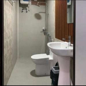 a bathroom with a white toilet and a sink at Serene haven in Kohīma