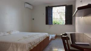 Un dormitorio con una cama y un escritorio y una ventana. en Cumbuco - Casa de praia com piscina e deck, en Cumbuco 43 fotos más