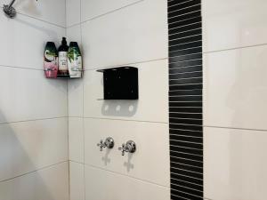 Central Melbourne 2BR Balcony Apartment في ملبورن: دش مع زجاجتين من الكحول على الحائط +27 صورة