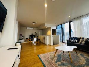 Central Melbourne 2BR Balcony Apartment في ملبورن: غرفة معيشة بها أريكة وطاولة