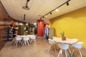 波梅齐亚B&B Hotel Pomezia Roma的一家店里有两张桌子和白色椅子