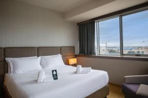 a hotel room with a large bed with a window at B&B HOTEL Trapani Crystal in Trapani