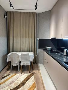 a kitchen with a table and chairs in a kitchen at Квартира ЖК Кербез in Aktau +2 photos