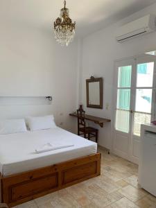 a bedroom with a bed and a chandelier at Anemoessa Studios in Pollonia
