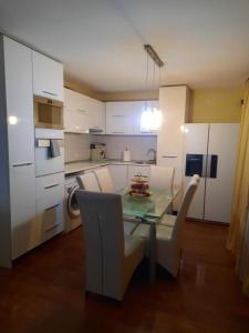 eine Küche mit Glastisch und weißen Schränken in der Unterkunft MihaiResidence in Craiova