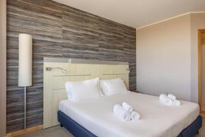 a bedroom with a bed with white towels on it at B&B Hotel Cherasco Langhe in Cherasco +21 photos