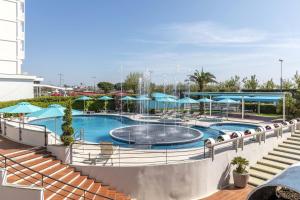 索托马里纳B&B Hotel Chioggia Airone的一座大楼内带蓝伞的大型游泳池 更多28张照片