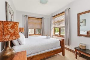 a bedroom with a bed with a lamp and a window at Chalet at Blue in Blue Mountains