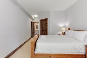 a bedroom with a large bed with white sheets at Chalet at Blue in Blue Mountains