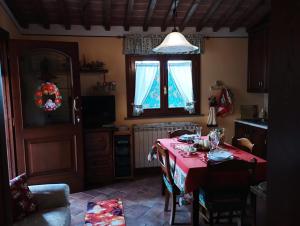 a kitchen with a table with a red table cloth at Melody house - dépendance in Castiglione del Bosco