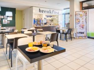 Un restaurante de comida rápida con platos de comida en las mesas. en B&B Hotel Ferrara, en Ferrara 25 fotos más