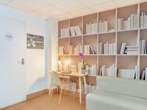 a room with a table and shelves with books at B&B Hotel Milano Sant'Ambrogio in Milan
