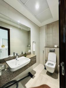 a bathroom with a sink and a toilet and a mirror at Executive 1BR - Perfect for DIFC & Trade Center in Dubai