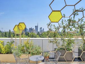 a balcony with chairs and tables and a view of the city at B&B Hotel Milano Cenisio Garibaldi in Milan +18 photos